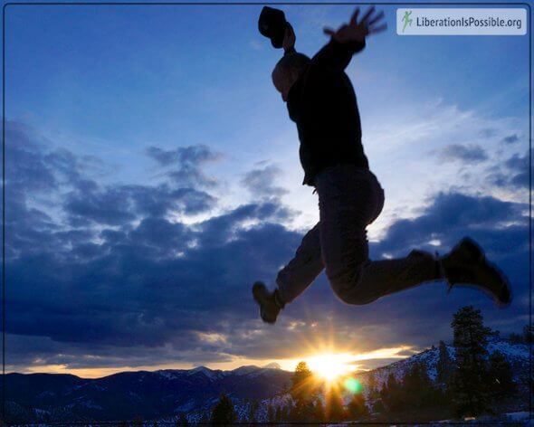 Silhouette of Anthony Twig Wheeler leaping into snow at sunset